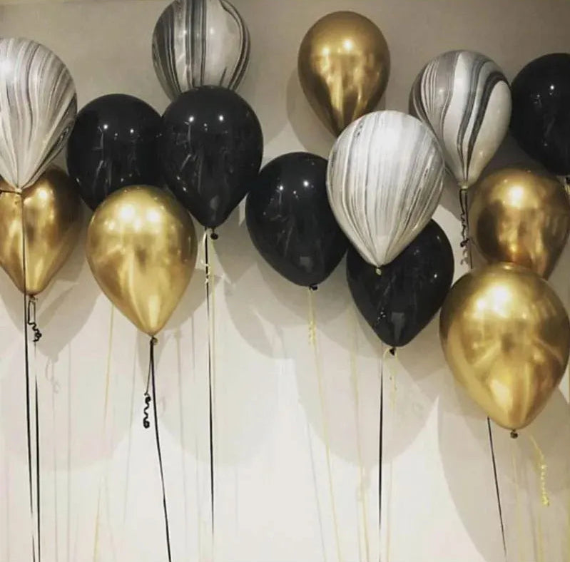 Decorative balloons in gold, black, and white on a neutral background