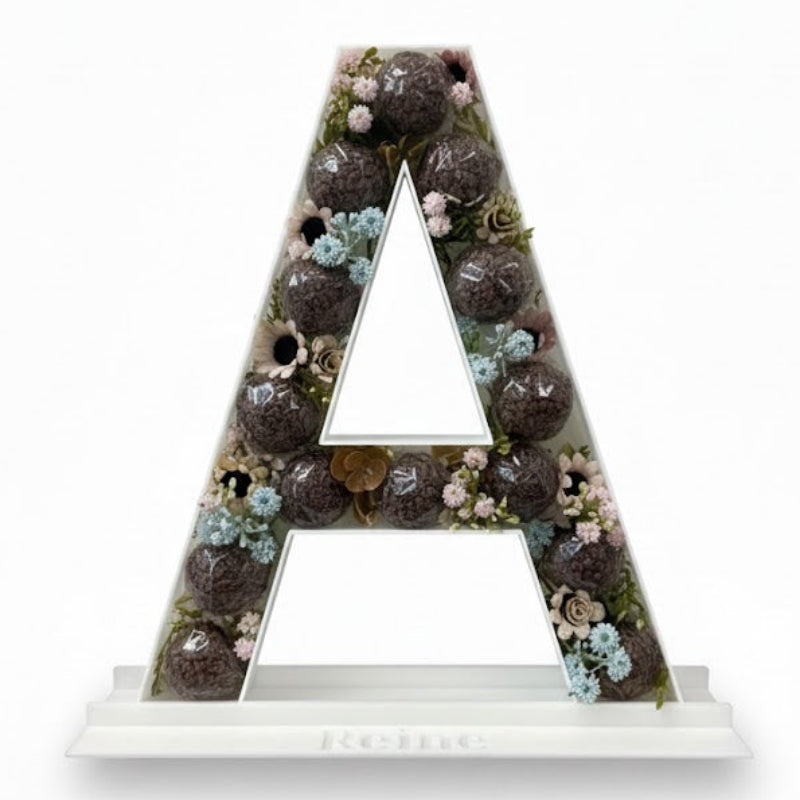 Decorative letter 'A' with a floral and succulent design 