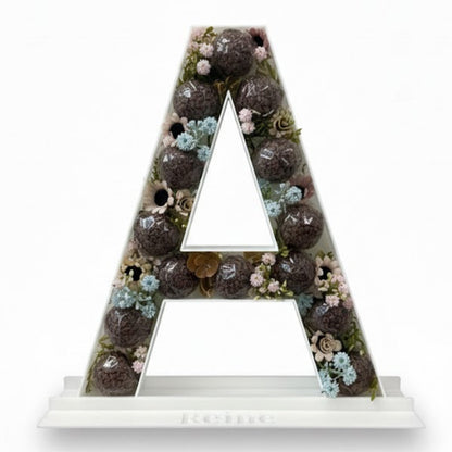 Decorative letter 'A' with a floral and succulent design 