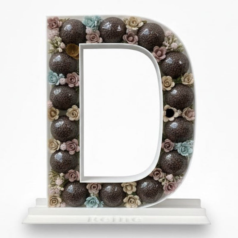 Decorative letter 'D' with floral elements 