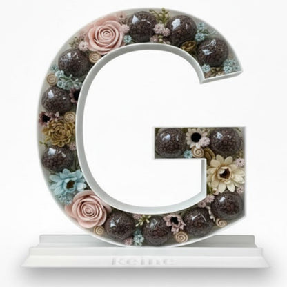 Decorative letter 'G' with floral elements 