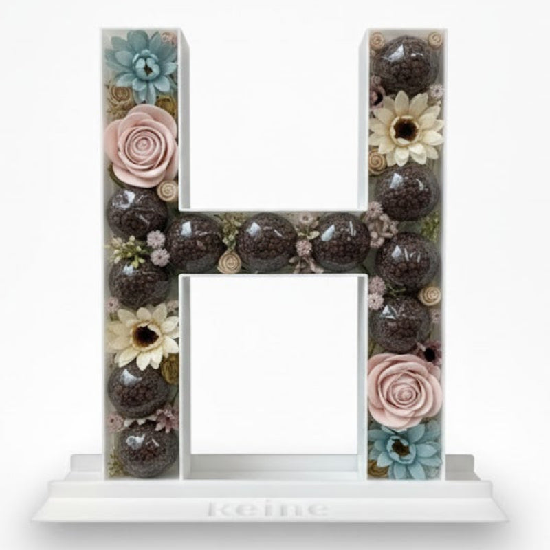 Decorative letter 'H' with floral elements 