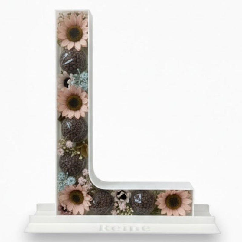 Decorative letter 'L' with floral design 