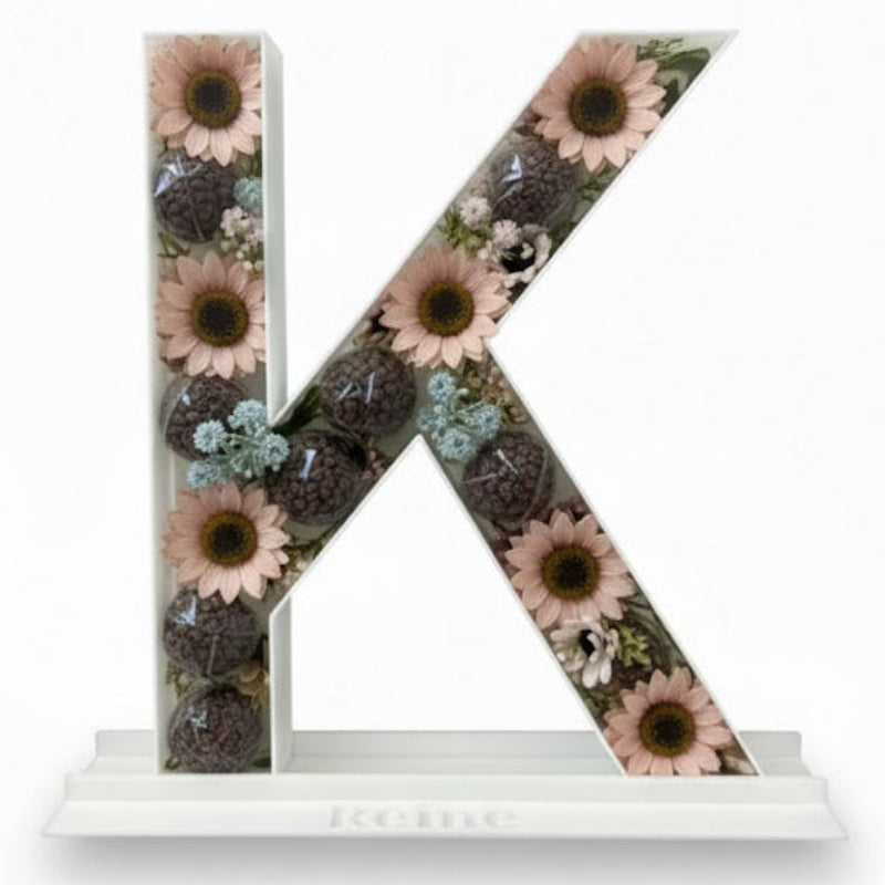 Decorative letter 'K' with floral design 